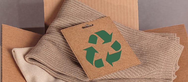 Tissus recyclés dans un carton et sigle économie circulaire