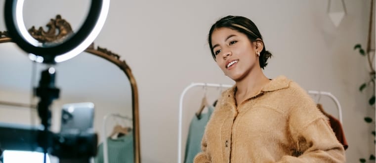 Créatrice de vêtements et influenceuse devant son projecteur et son téléphone