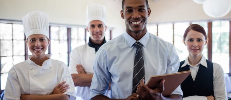 Des employés de restaurant souriants en uniformes