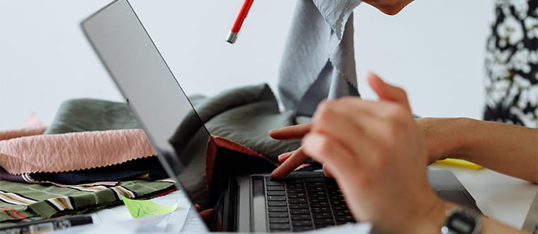 Deux personnes choississant des matières premières textiles sur un bureau