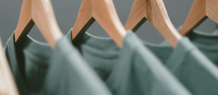 Portant de prototypes de t-shirts verts dans un atelier de production
