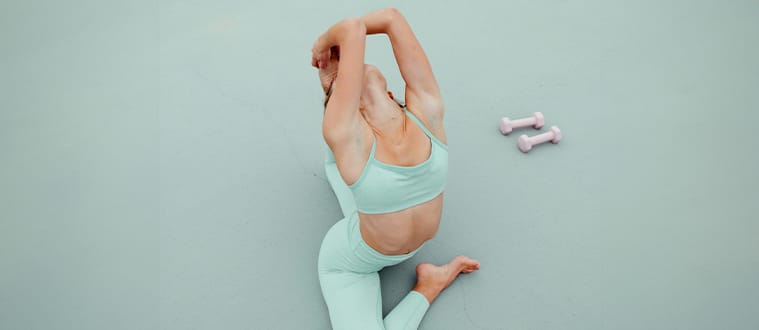 Femme faisant du yoga en legging bleu et brassière bleue
